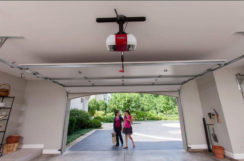 Garage interior with a Craftsman garage door opener and two women walking outside.